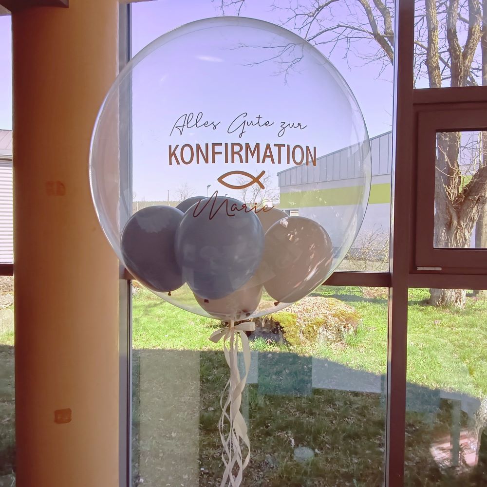 Transparenter Bubbleballon mit pinkem Konfetti, Aufdruck 'Alles Gute zur KONFIRMATION Greta 8. Juni 2025', auf rosa-pinker Ballonbasis