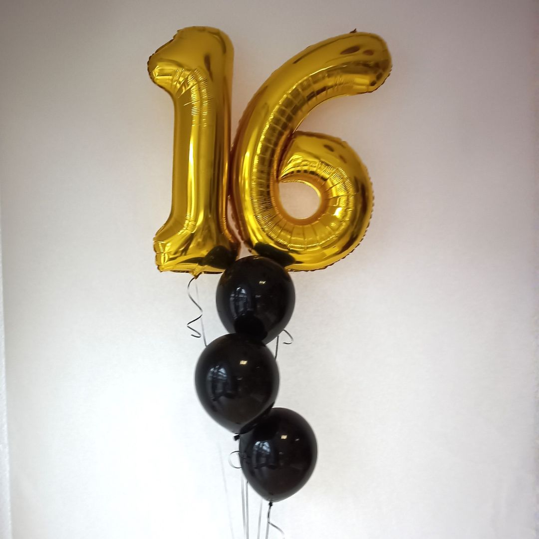 Goldene Folienballons in Form der Zahlen 1 und 6 mit schwarzen Latexballons auf hellem Hintergrund.