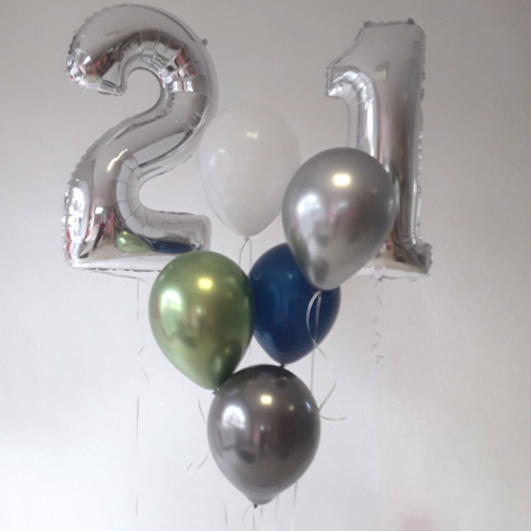 Silberne Folienballons in Form der Zahlen 2 und 1 mit grünen, blauen und silbernen Latexballons.