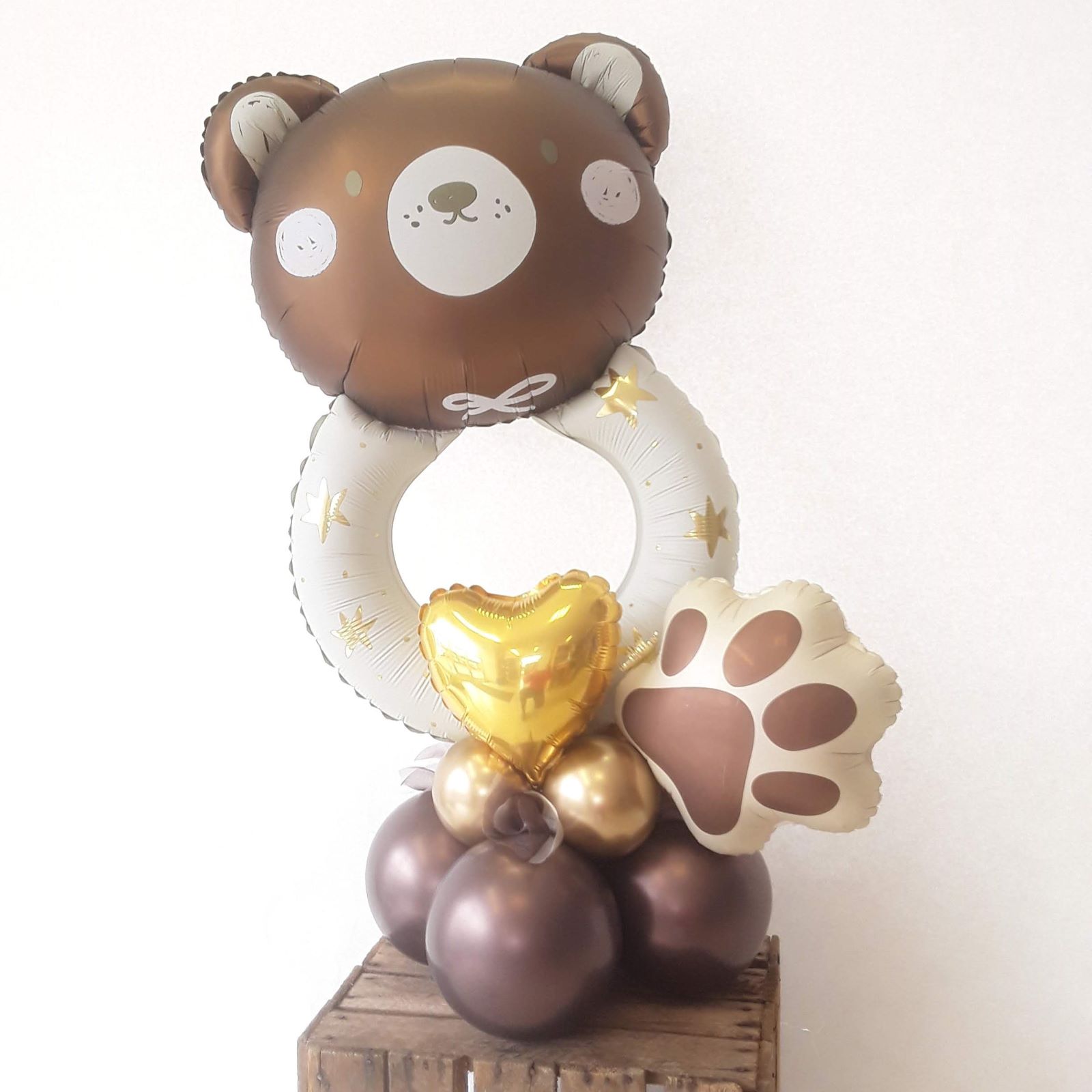 Tischdeko mit braunem Bären-Ballon mit weißen Sternen, goldfarbenem Herz-Ballon und Tatzen-Folienballon auf braun-goldener Ballonbasis