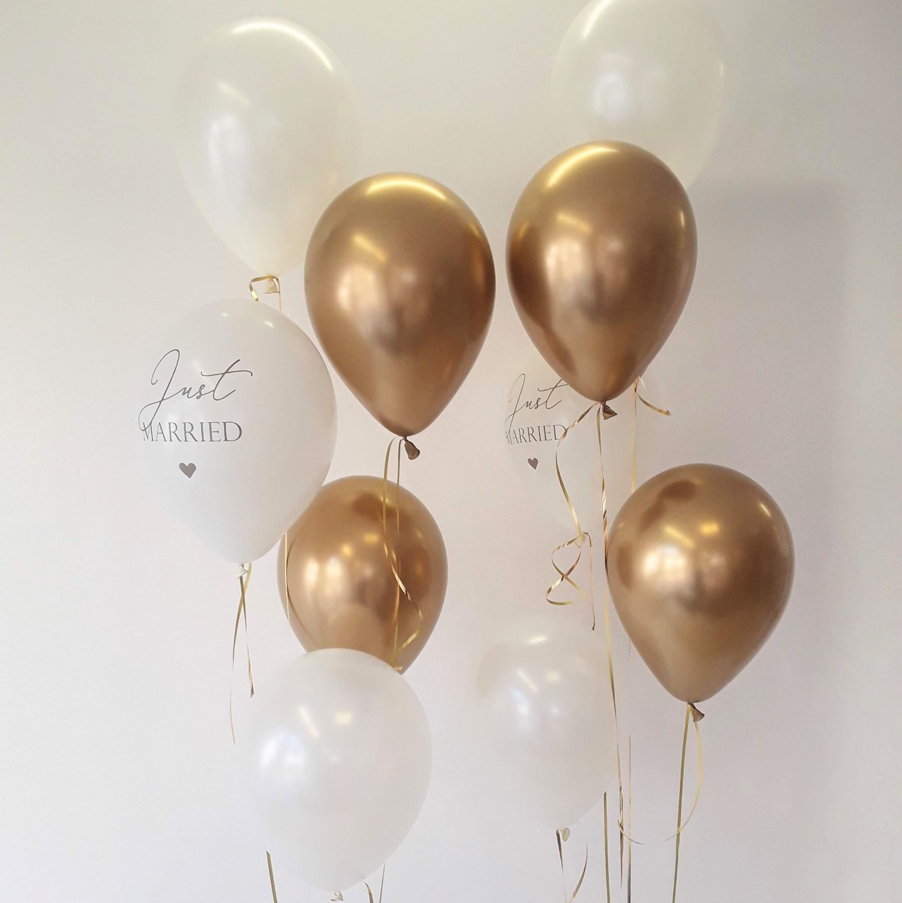 Ballonbouquet mit weißen und goldenen Luftballons, zwei mit Aufdruck 'Just Married' in eleganter Schrift.