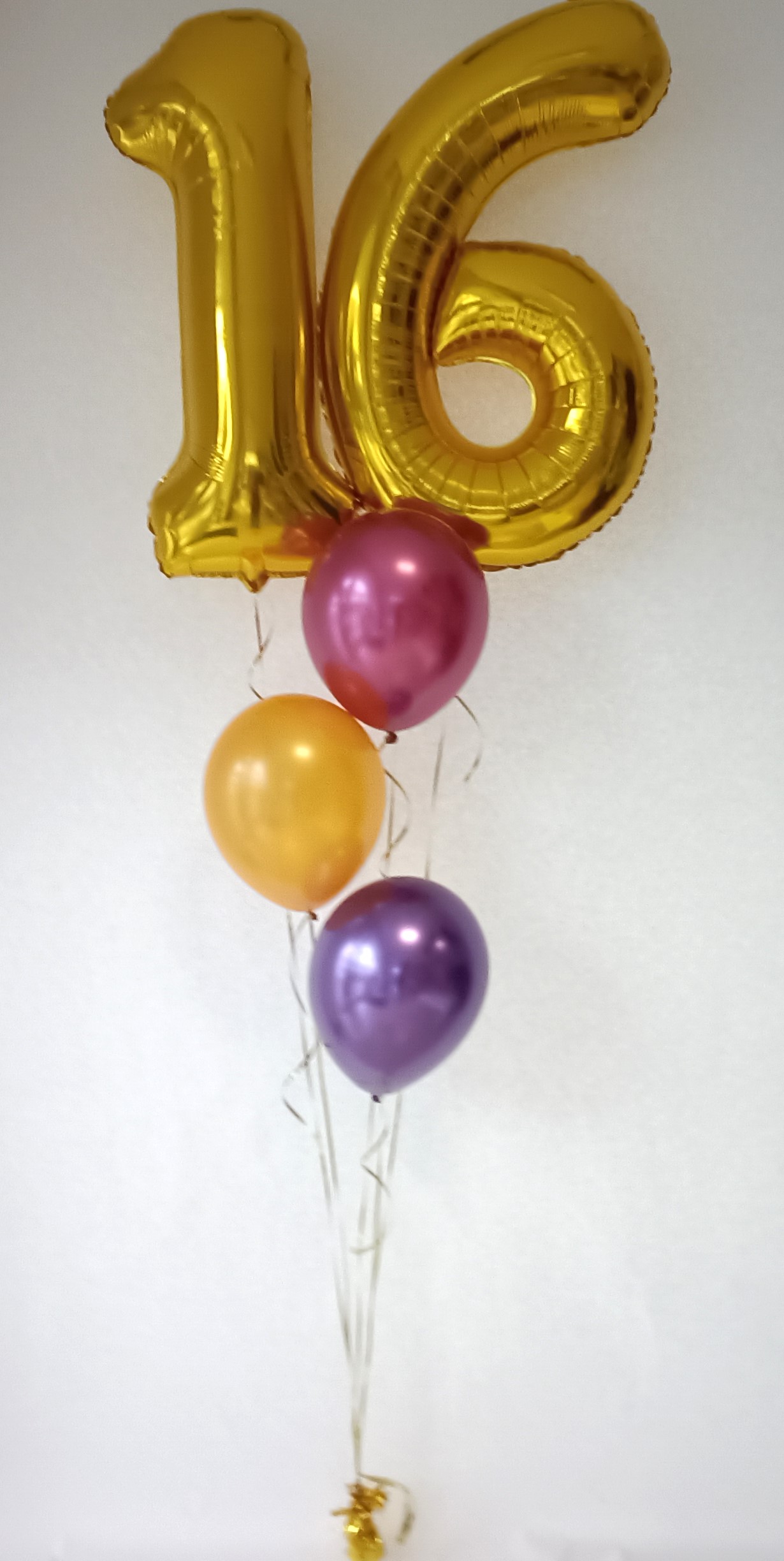 Goldene Folienballons in Form der Zahlen 1 und 6 mit pinken, goldenen und violetten Latexballons. mit goldenem Ballongewicht