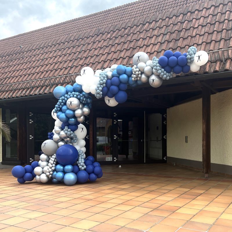 Großer Ballon-Halbbogen in verschiedenen Blautönen, Weiß und Silber am Eingang