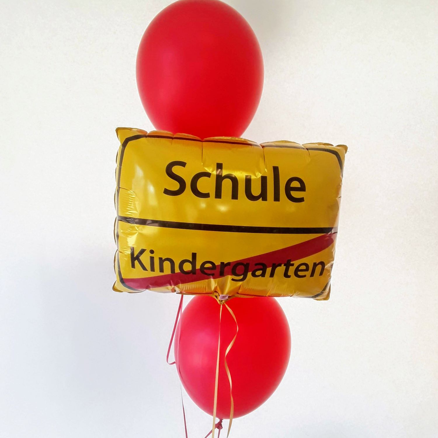 Ballonarrangement mit rechteckigem Folienballon im Straßenschild-Design 'Schule' statt 'Kindergarten' und roten Latexballons