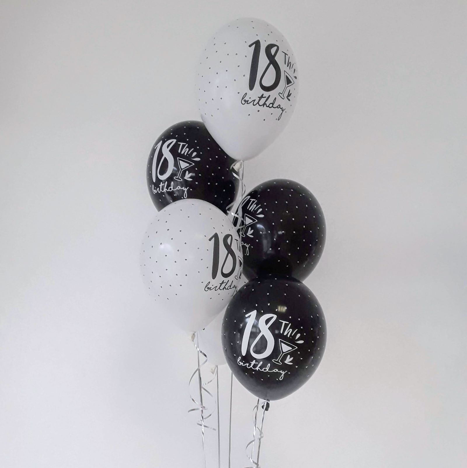 Ballonbouquet mit fünf Luftballons in Schwarz und Weiß, jeweils mit Aufdruck '18th Birthday' und kleinen Punkten.