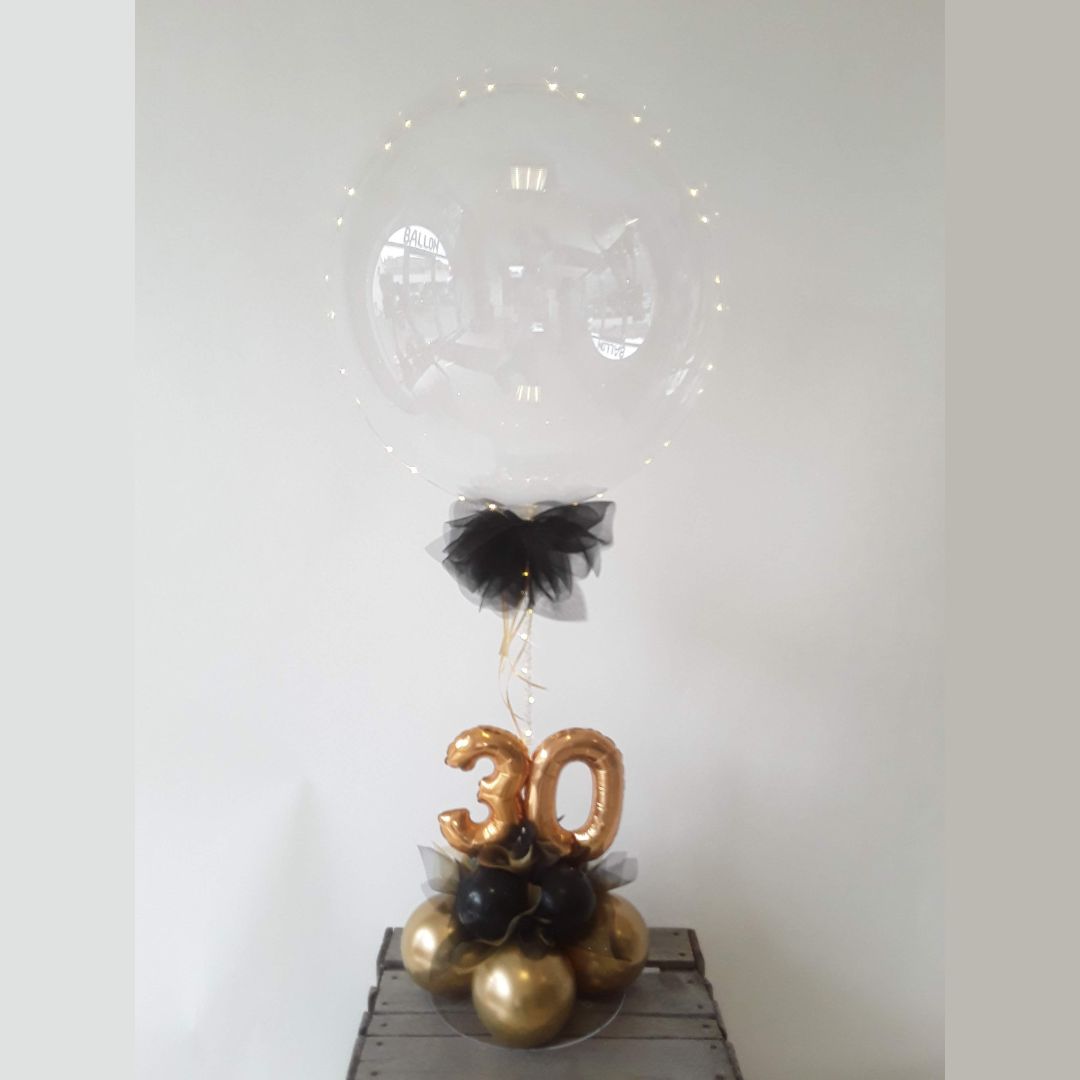 Transparenter Ballon mit Lichterkette, schwarze Schleife, goldene 30 auf Ballonbasis