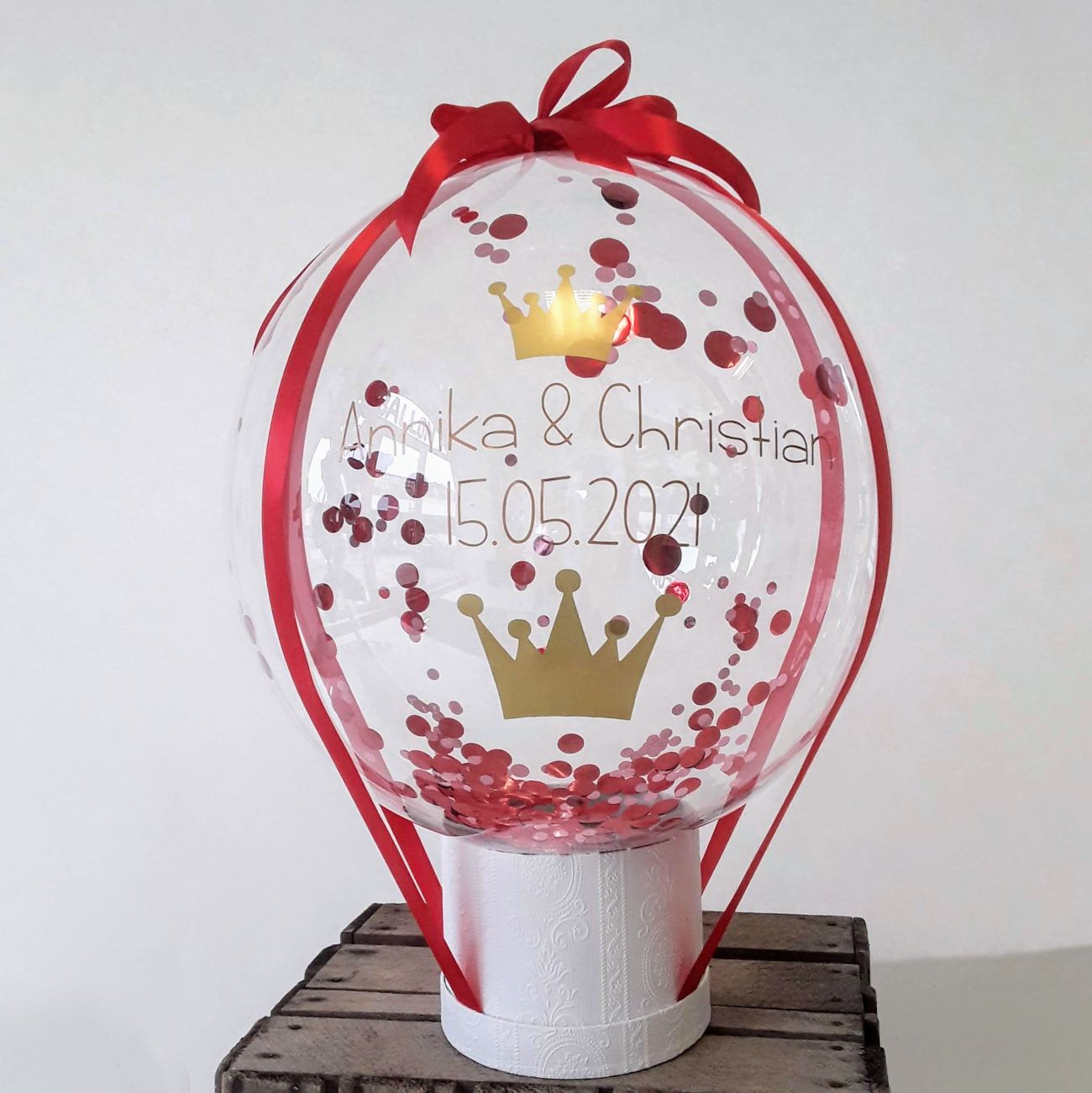 Heißluftballon zur Hochzeit mit goldener Krone, roten Konfettis und personalisiertem Schriftzug