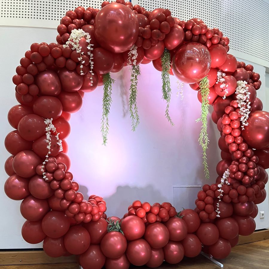 Kraftvoller Rundbogen komplett in Rot mit floralen Hängeelementen, dekoriert mit weißen Blüten & grüner Ranke