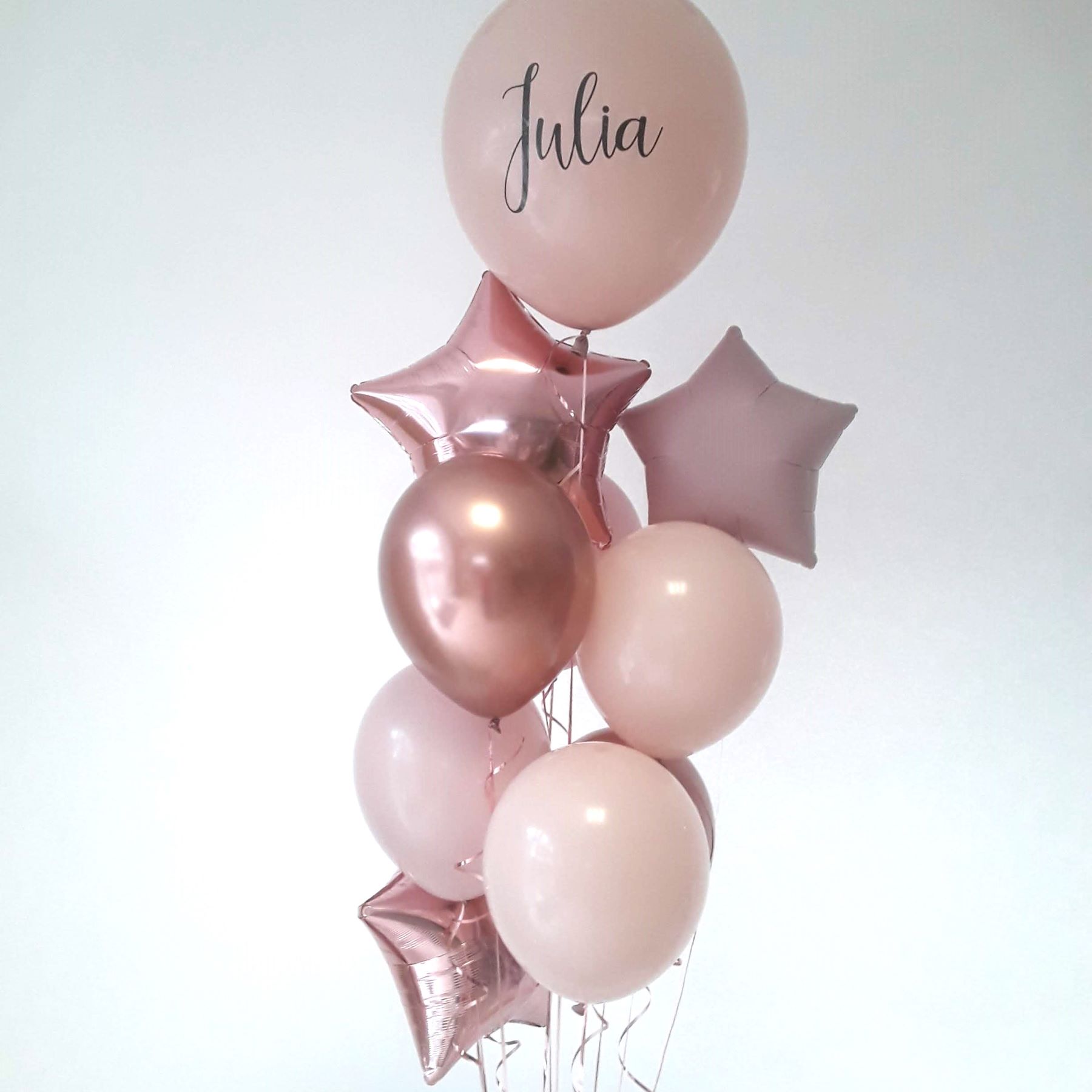 Ballonstrauß mit roséfarbenen Latexballons, metallisch glänzenden Foliensternen und einem personalisierten Namensballon mit dem Namen Julia