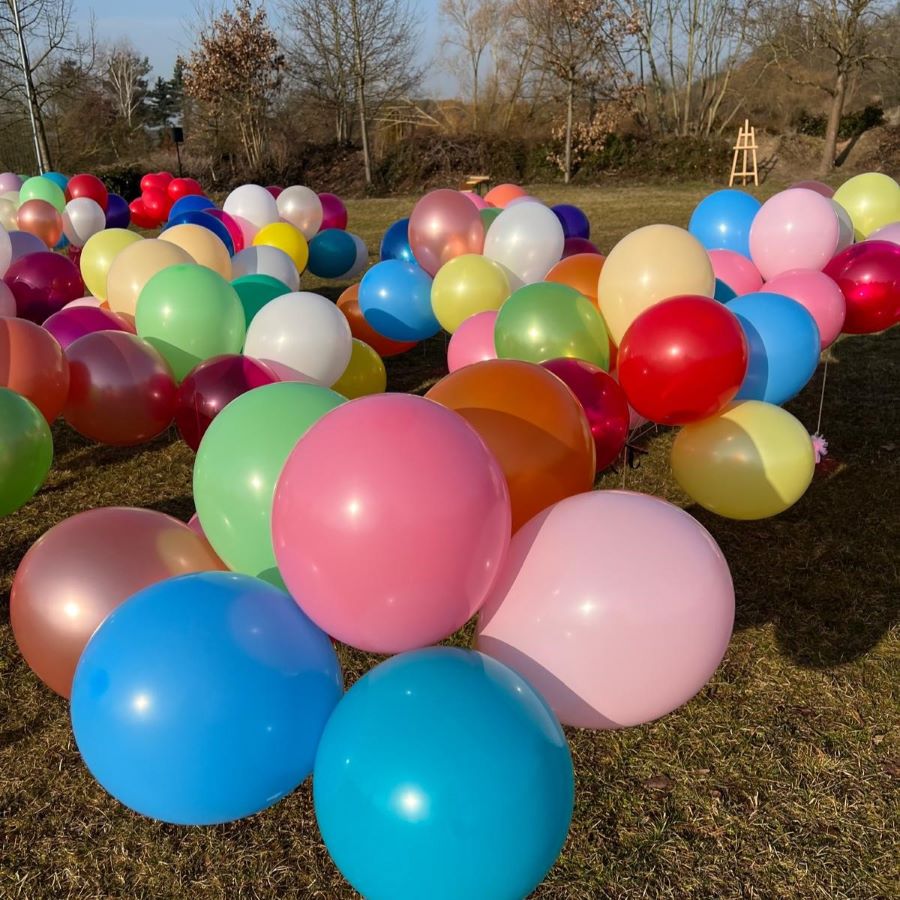 Bunte Latexballons in vielen Farben hängen unter einer Decke, alle mit Schnüren versehen-3