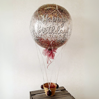 Geburtstagsballon mit Aufschrift "Happy birthday" im Heißluftballon-Stil mit Glitzer-Konfetti, Korb und pinker Schleife