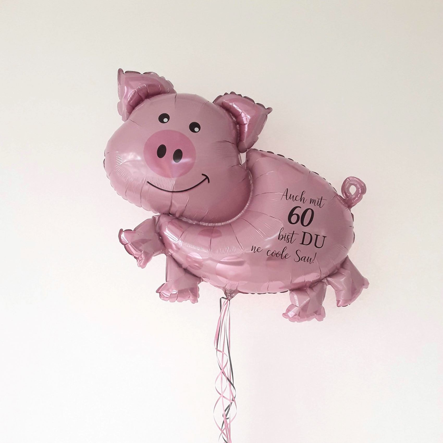 Rosa Folienballon in Schweinchenform mit Aufdruck 'Auch mit 60 bist DU ne coole Sau!'