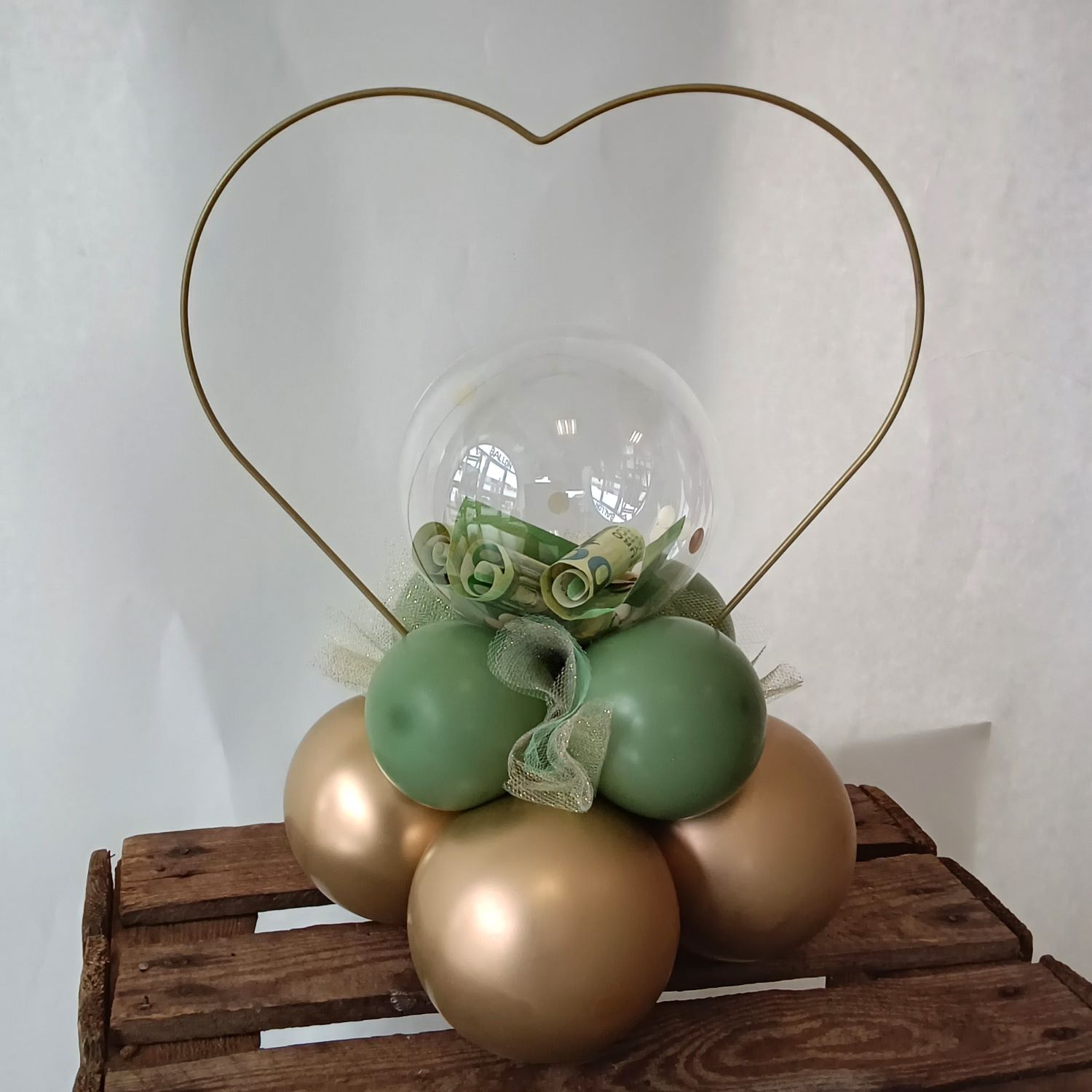 Tischdeko mit kleinem transparentem Ballon gefüllt mit Geldscheinen, grün-goldenen Ballons & goldenem Herz-Ring