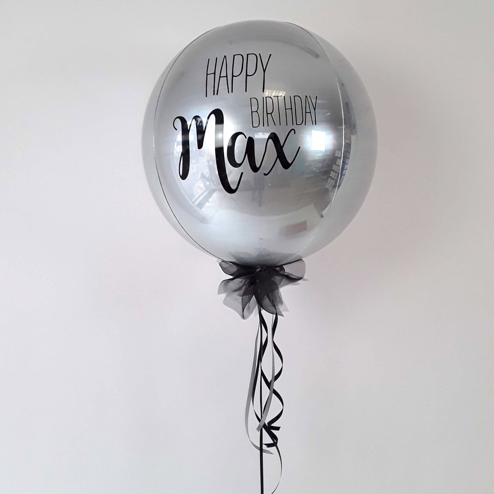 Ballonkugel mit schwarzer Schleife, silbernem Aufdruck Happy Birthday  und Name Max.