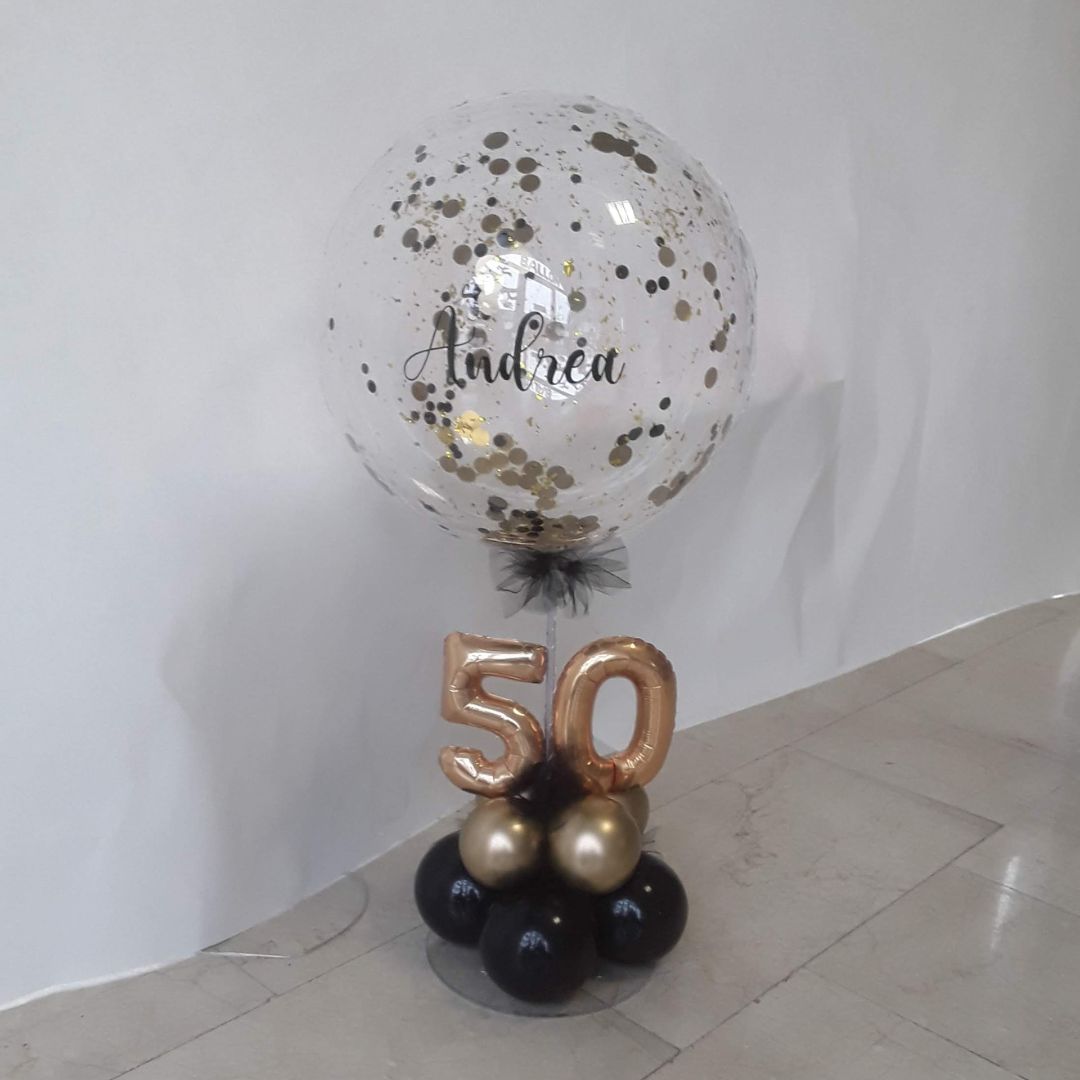 Transparenter Ballon mit goldenen Konfetti, personalisiert mit 'Andrea' und Ballonbasis mit goldener 50