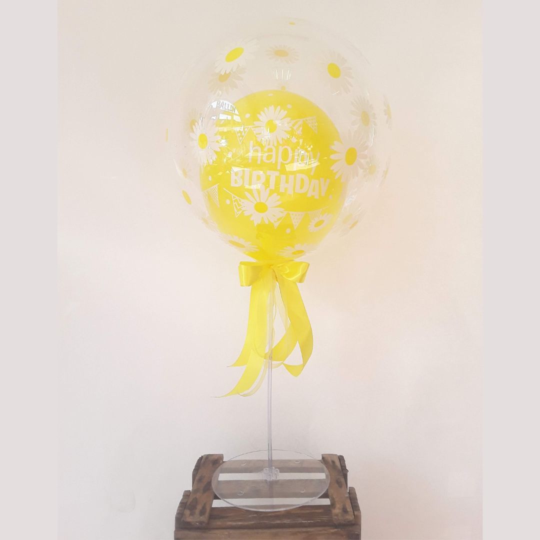 Transparenter Ballon mit gelbem Innenballon und Gänseblümchen, gelbe Schleife