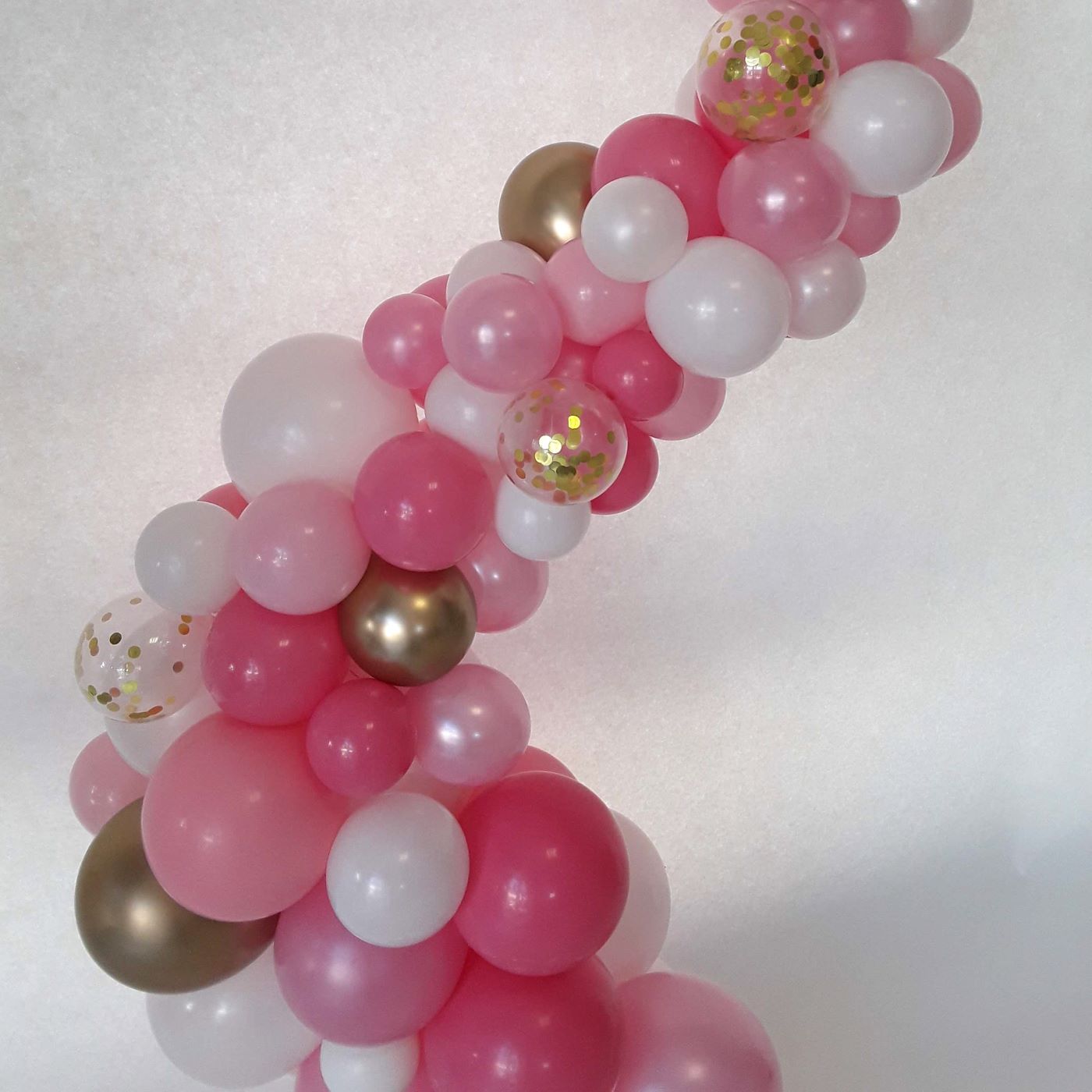 Ballonsäule in Rosa, Pink und Weiß mit goldenen Akzenten und Konfettiballons in organischer Form