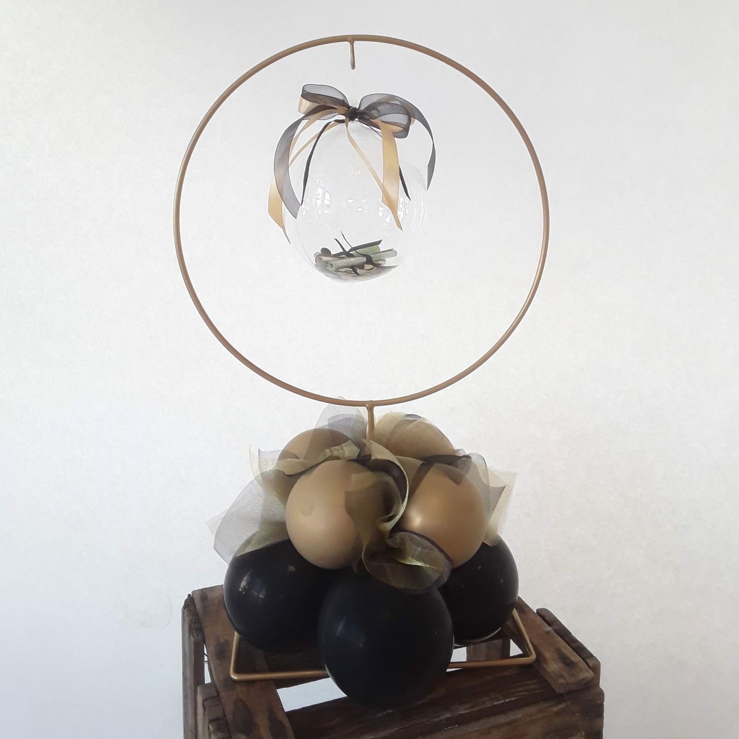 Ballon-Geldgeschenk mit gold-schwarzer Ballon-Basis, auf Metallständer mit durchsichtiger Ballonkugel für Geldscheine mit Schleifen