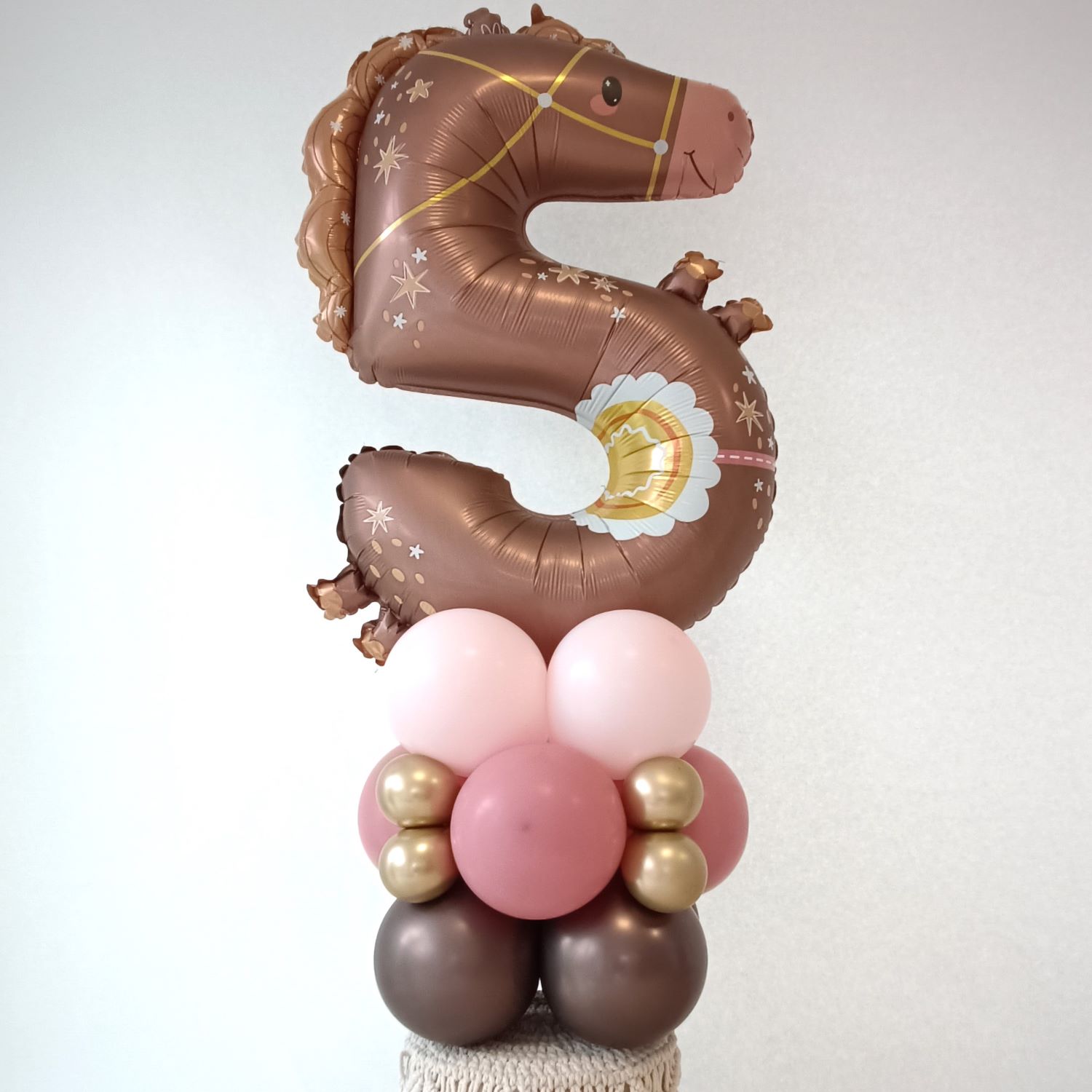 Ballondekoration mit Pferdeballon in Zahl 5-Form, auf Ballonpodest in Rosa und Gold