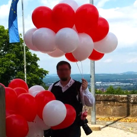 Konfetti-Bubble mit schwarzem Schriftzug „Congrats Anna“ und kleinem Graduierten-Hut, luftgefüllt auf einem silbernen Ballonfuß als Tischbouquet.-2