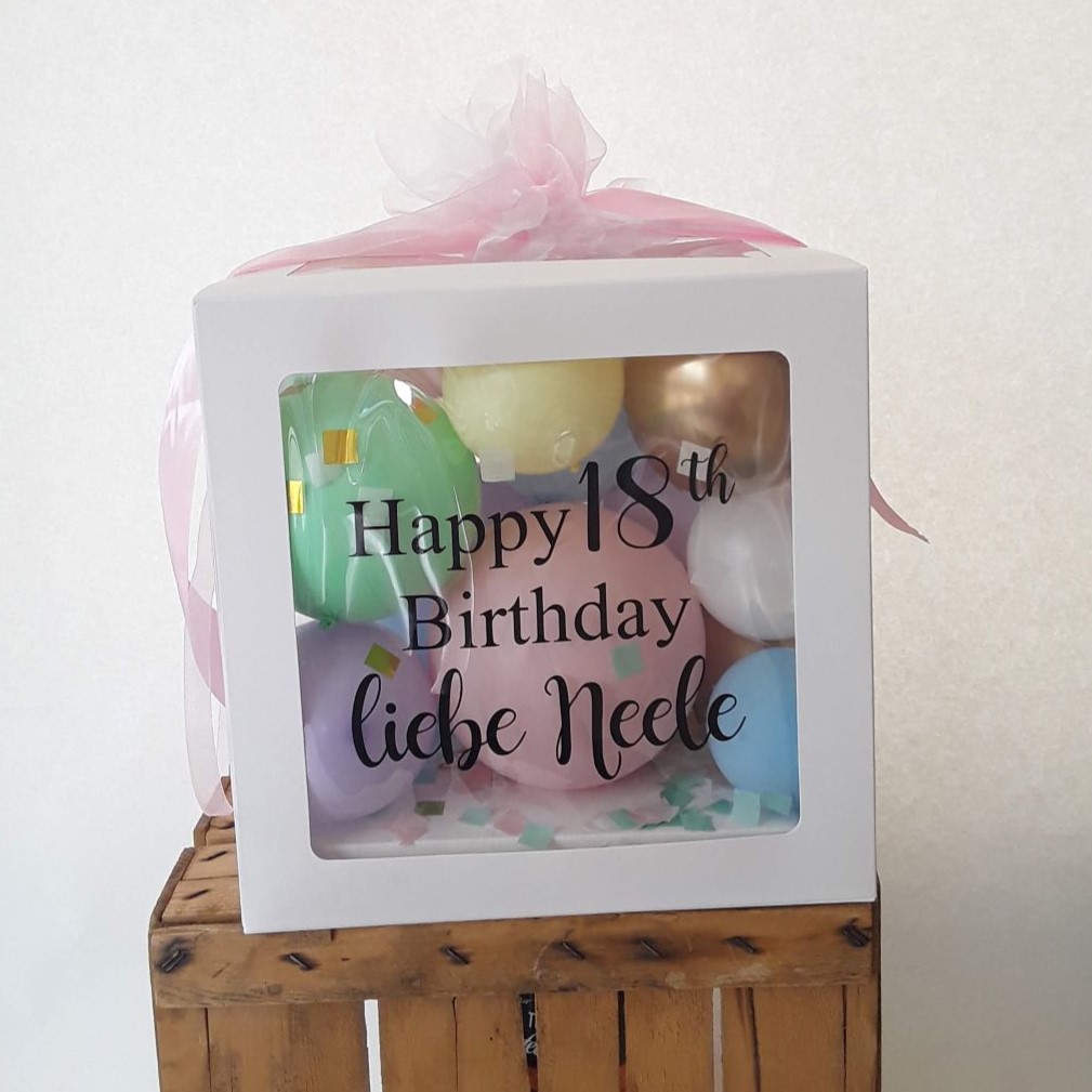 Ballonbox mit Aufdruck 'Happy 18th Birthday liebe Neele', gefüllt mit bunten Ballons in Pastell und Konfetti