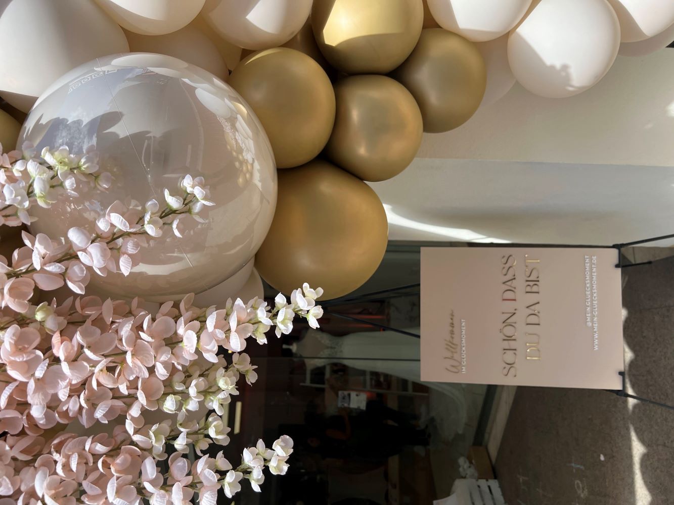 Ballons in beige und creme mit Trockenblumen vor Schaufenster