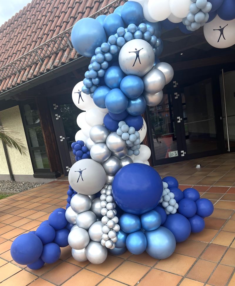 Großer Ballon-Halbbogen in verschiedenen Blautönen, Weiß und Silber am Eingang