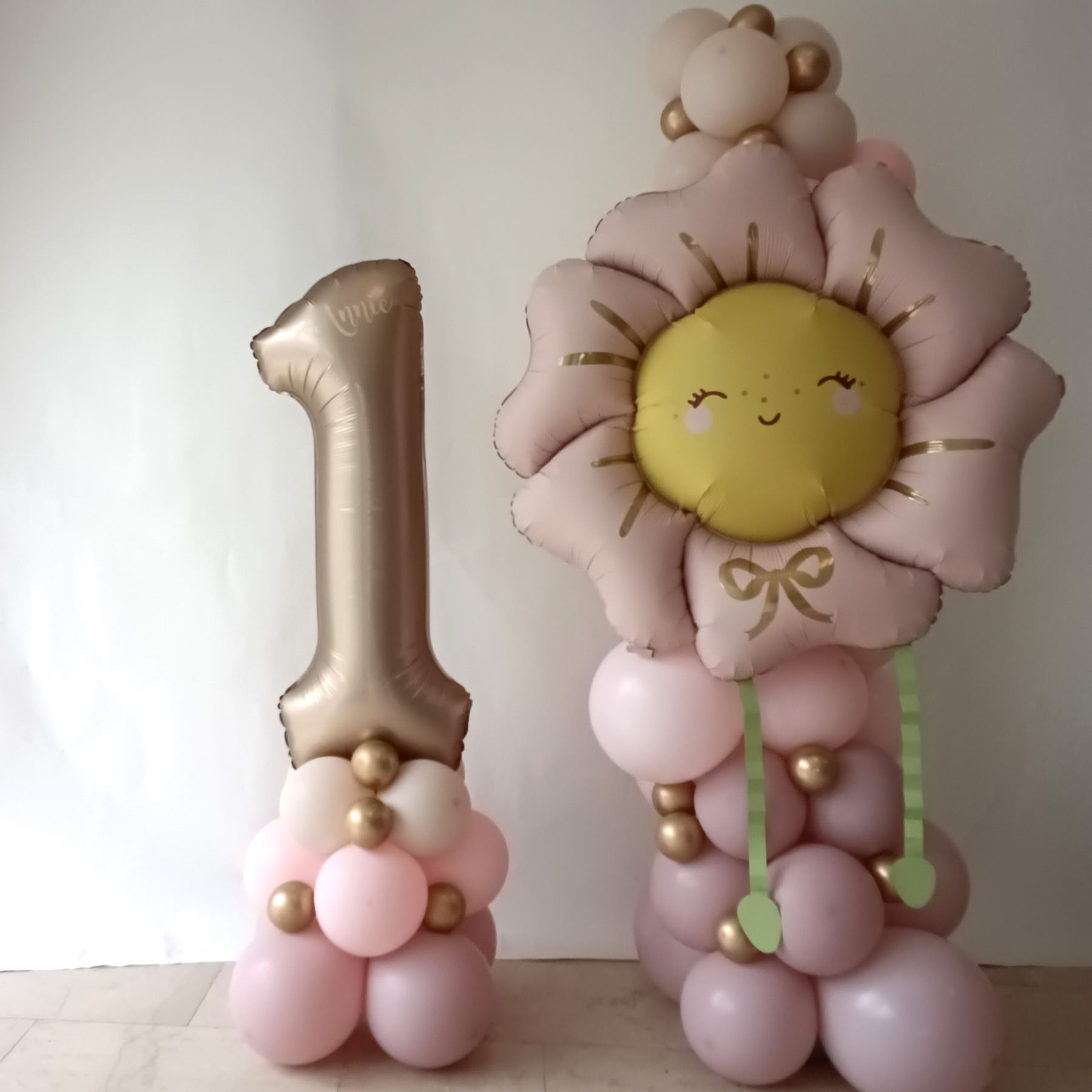 Ballondeko mit rosa-goldener Zahl 1 und lächelnder Blumen-Sonne.