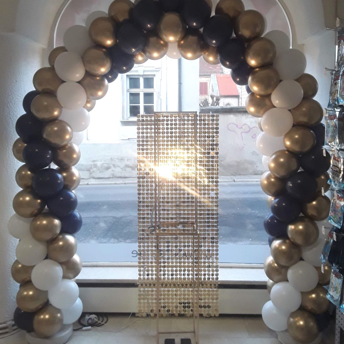 Rundbogen aus navyblauen, goldenen und weißen Ballons, symmetrisch aufgebaut in einem Eingangsbogen